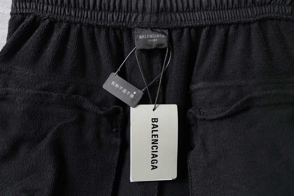 Balenciaga pants hang tags on elastic waistband, printed labels visible on dark fabric