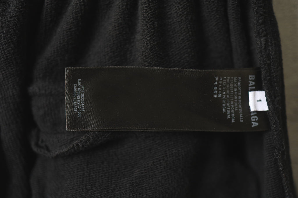 Balenciaga pants care label inside pocket, printed on dark charcoal fabric