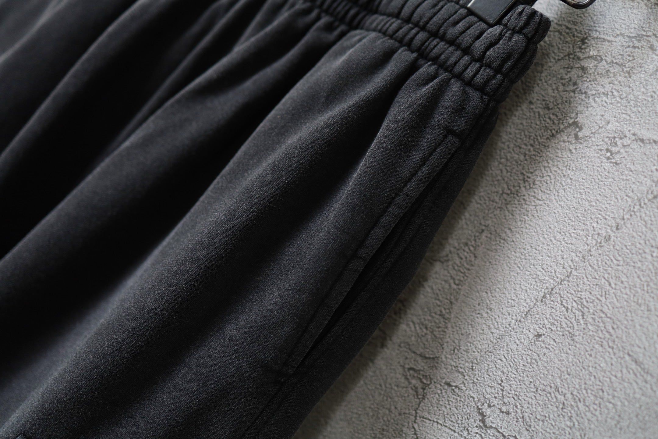 Balenciaga cargo pants fabric close-up with gathered seams and dark charcoal texture