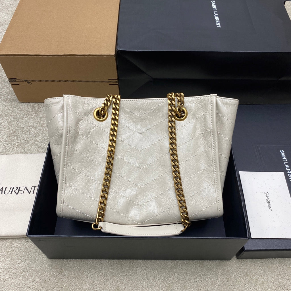 White quilted leather tote bag with gold chain straps and top pull details