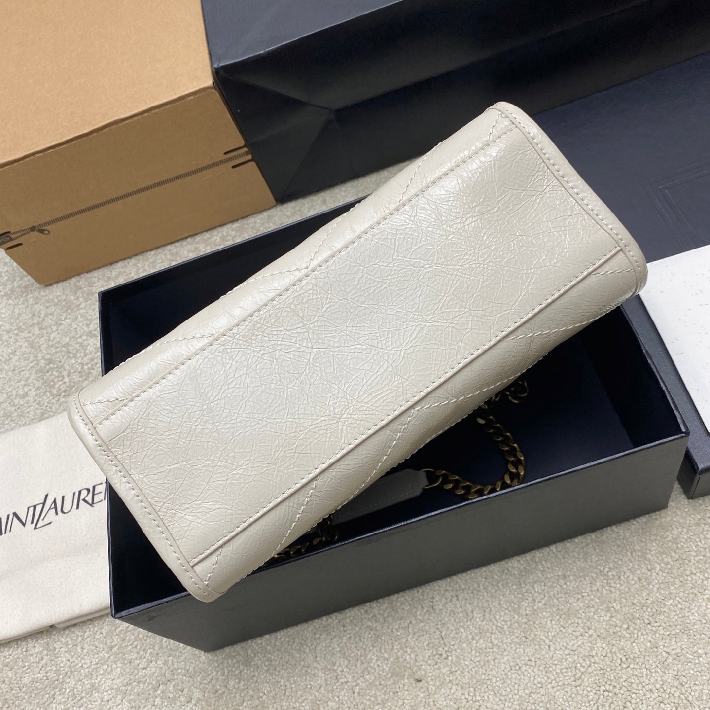 White leather clutch bag with gold chain strap and smooth textured body