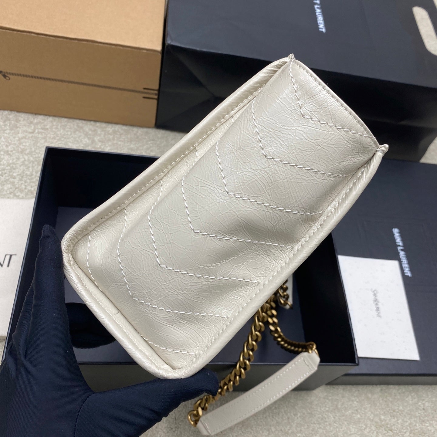 White leather clutch bag with gold chain strap and stitched quilted design