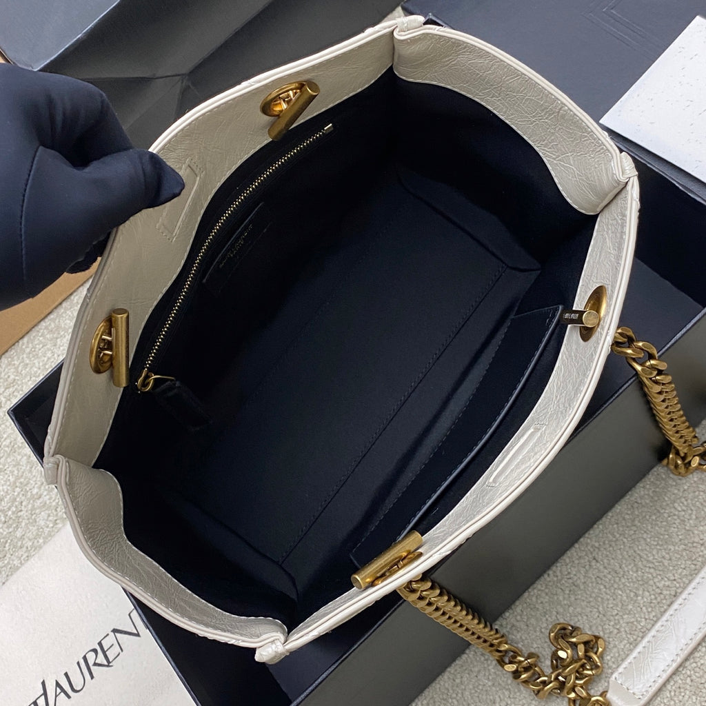 White bag opening with black lining, zipper, gold hardware, and gold chain strap