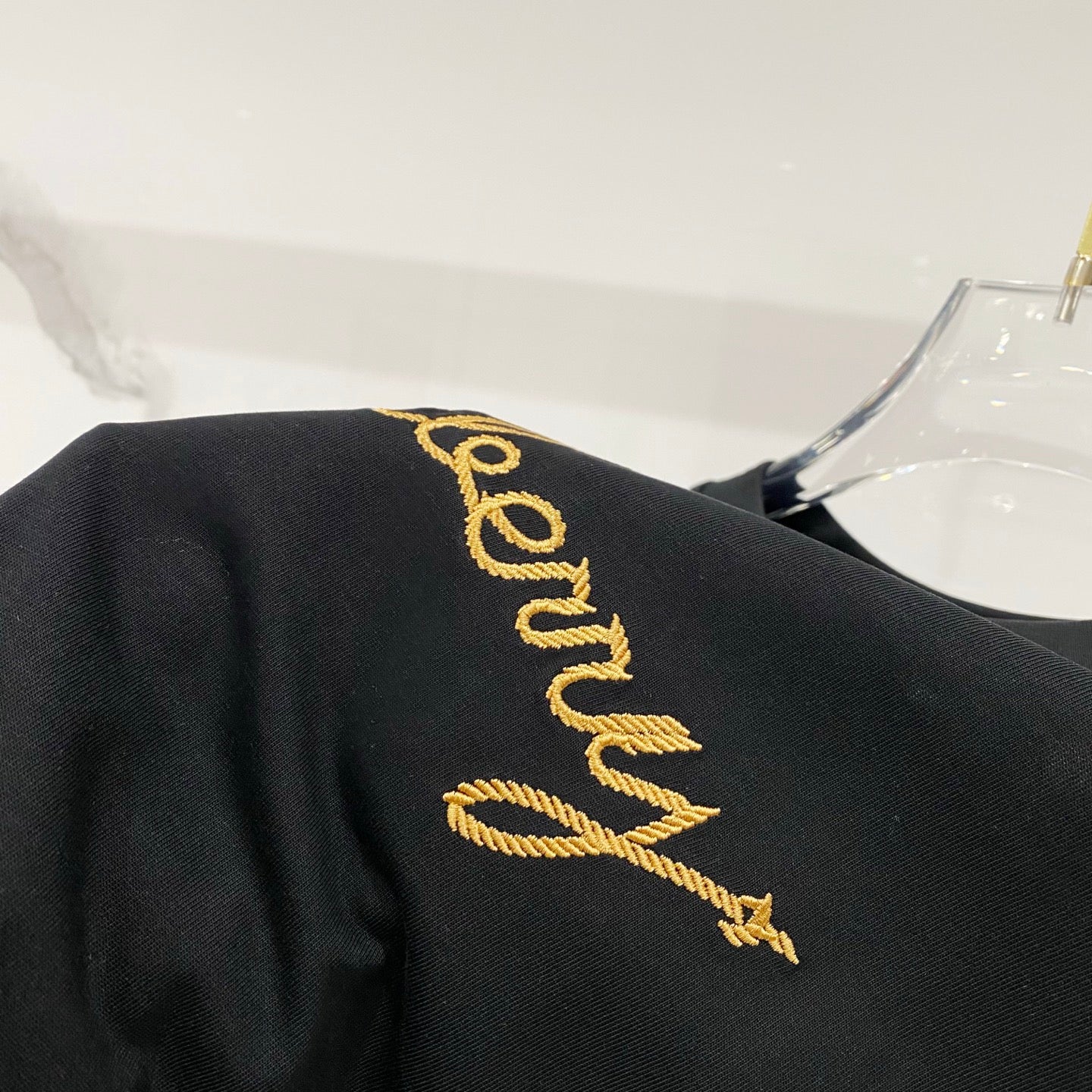 Black T-shirt back with vertical gold Burberry script logo