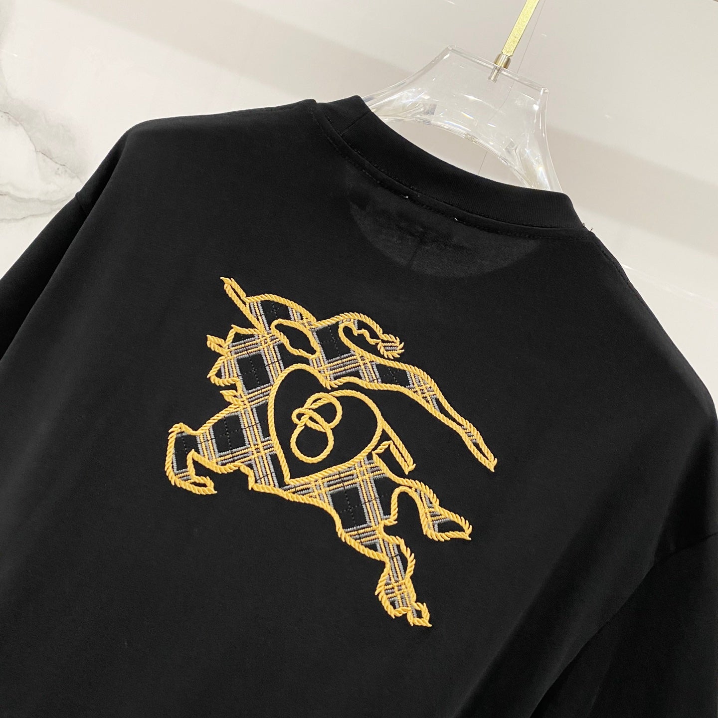 Black crewneck T-shirt with gold knight graphic and scarf on back