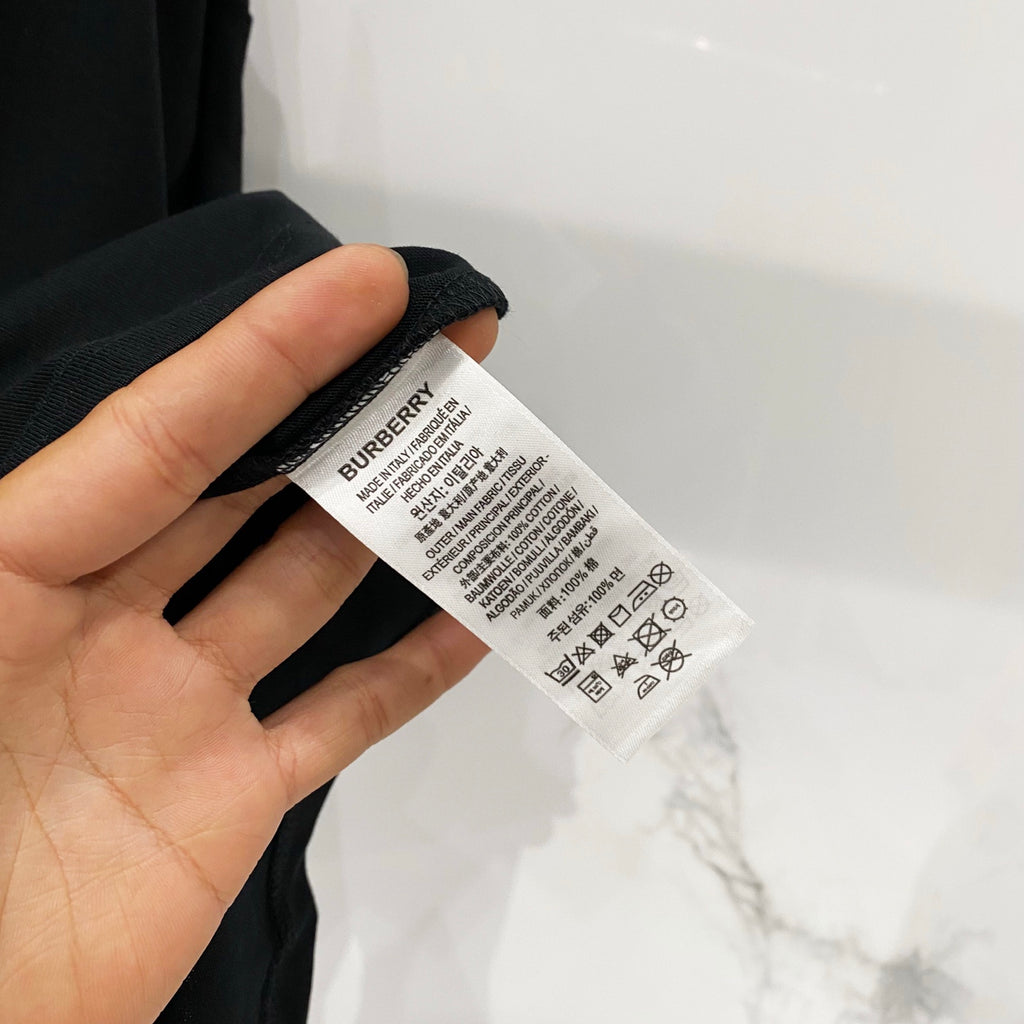 Black T-shirt care label tag with printed Burberry details