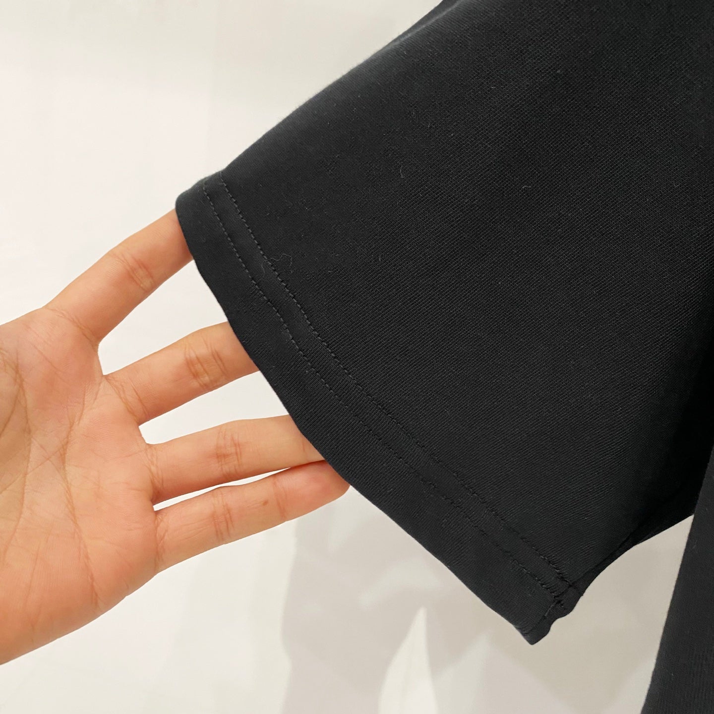 Black T-shirt sleeve hem with visible stitching