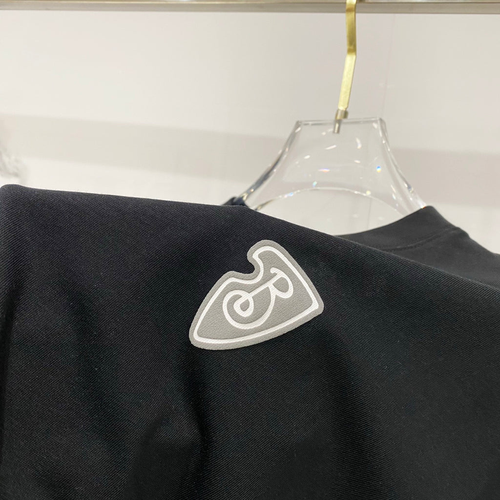 Black T-shirt shoulder area with heart emblem patch