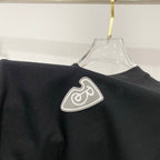 Black T-shirt shoulder area with heart emblem patch