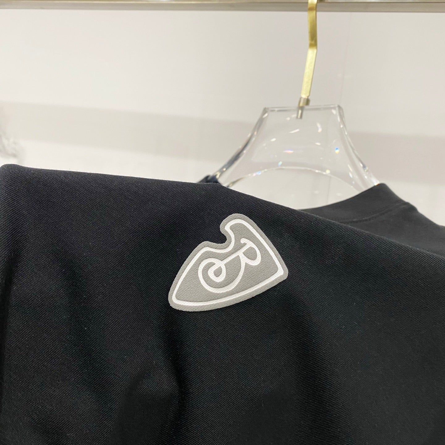 Black T-shirt shoulder area with heart emblem patch