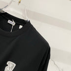 Black T-shirt with heart emblem on chest and crew neckline