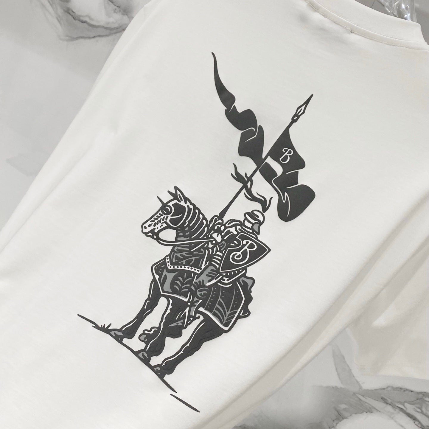 White Burberry T-shirt with large black polo-style graphic on front.