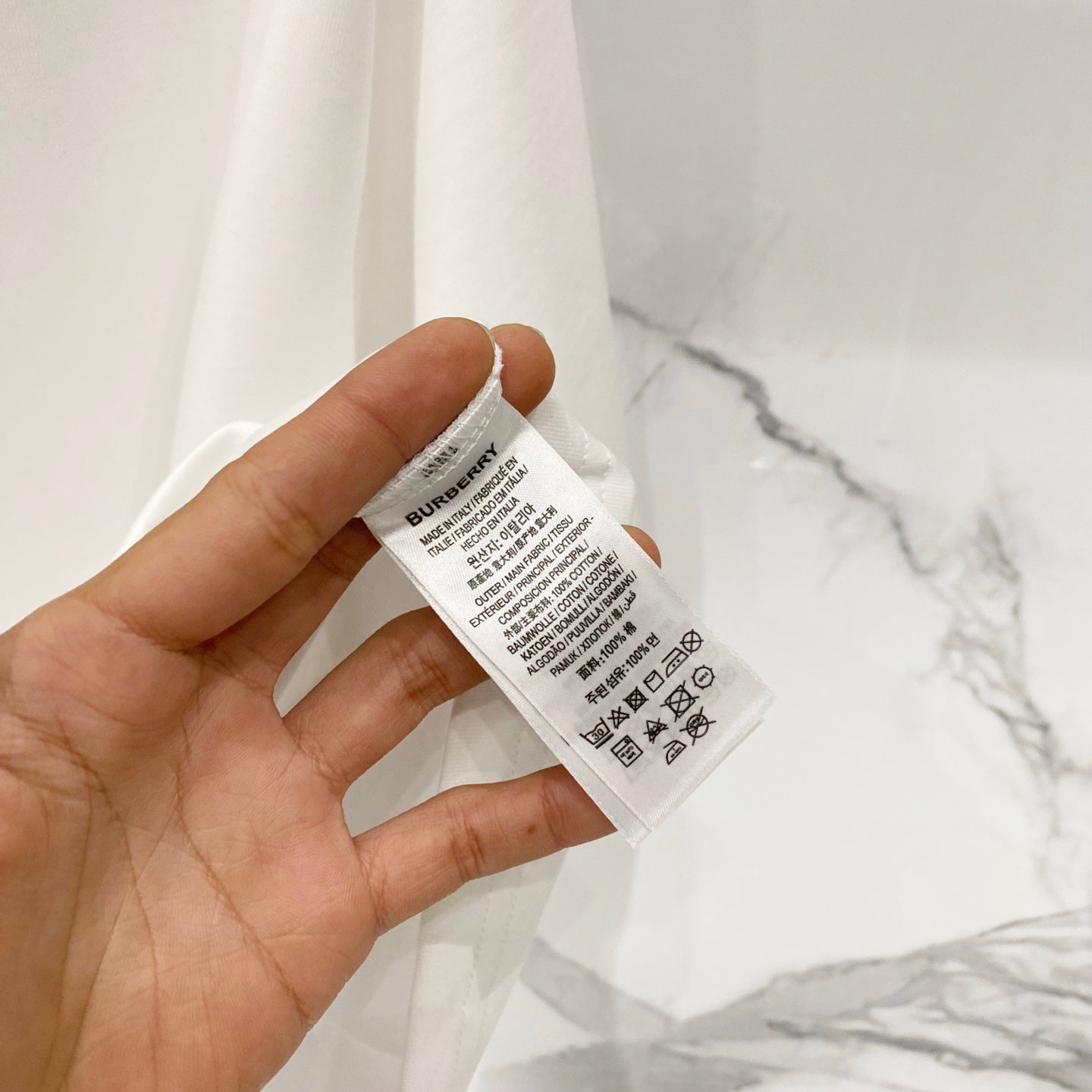 White Burberry T-shirt care label inside neck area.