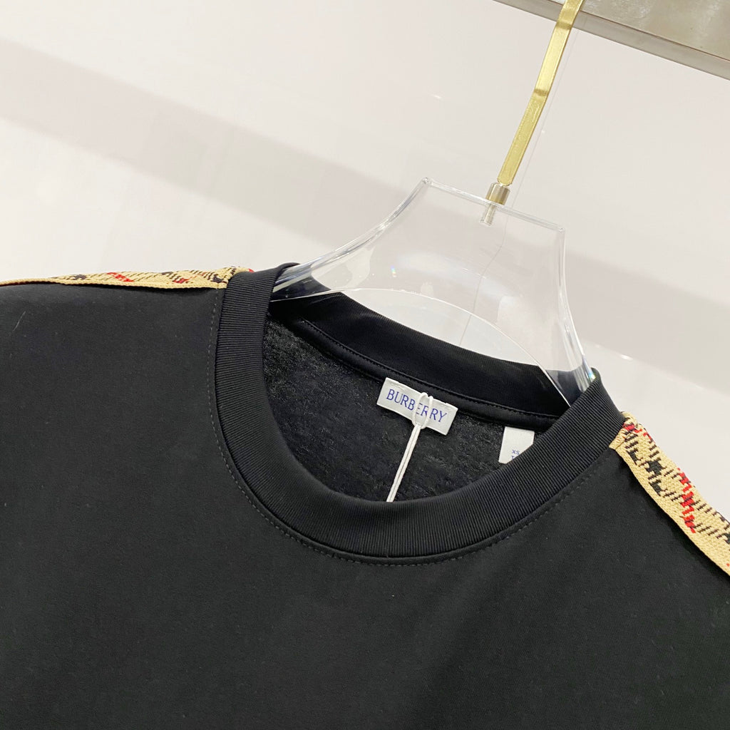 Black Burberry crew-neck T-shirt close-up, neckline seam and neck label.