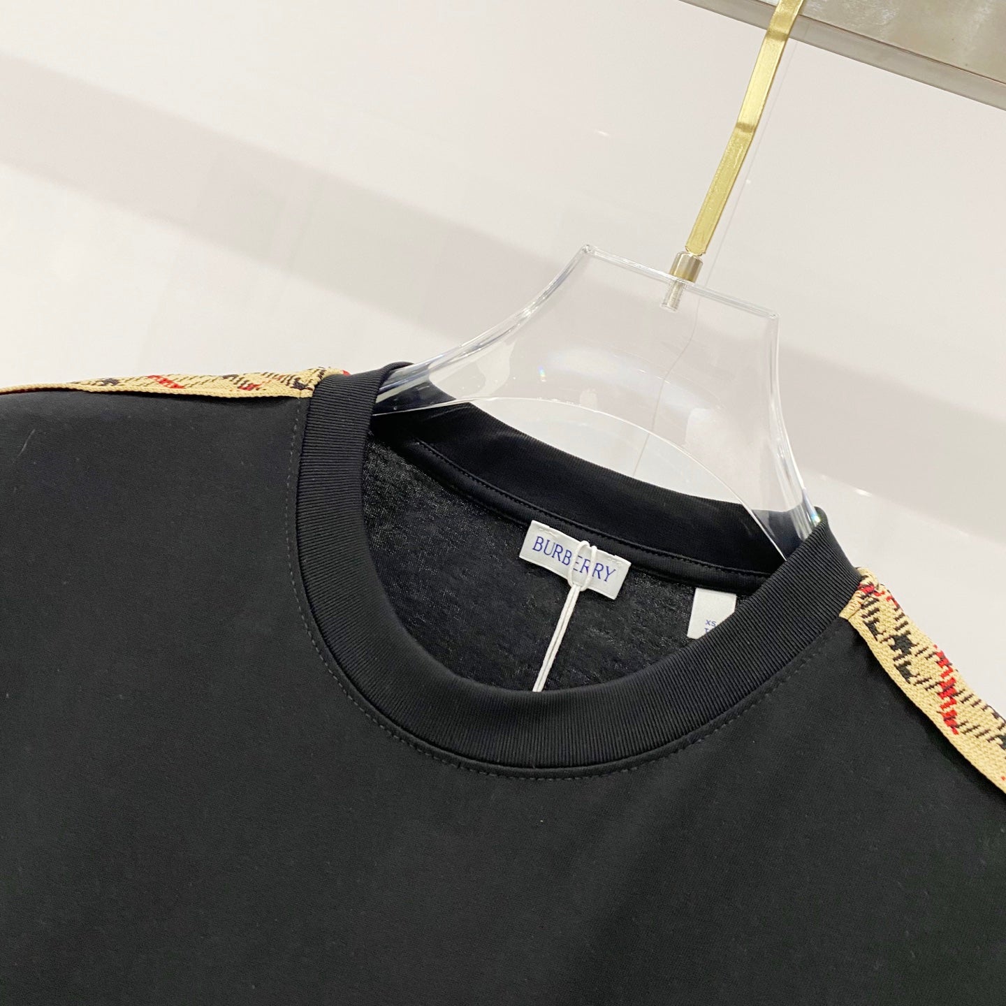 Black Burberry crew-neck T-shirt close-up, neckline seam and neck label.