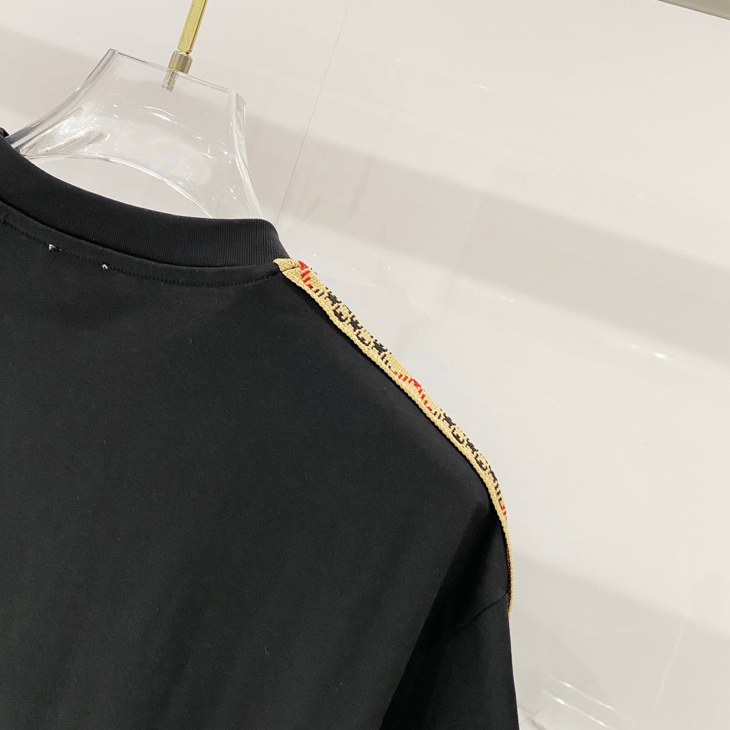 Black Burberry T-shirt neckline and shoulder close-up, crew neck with trim detail.