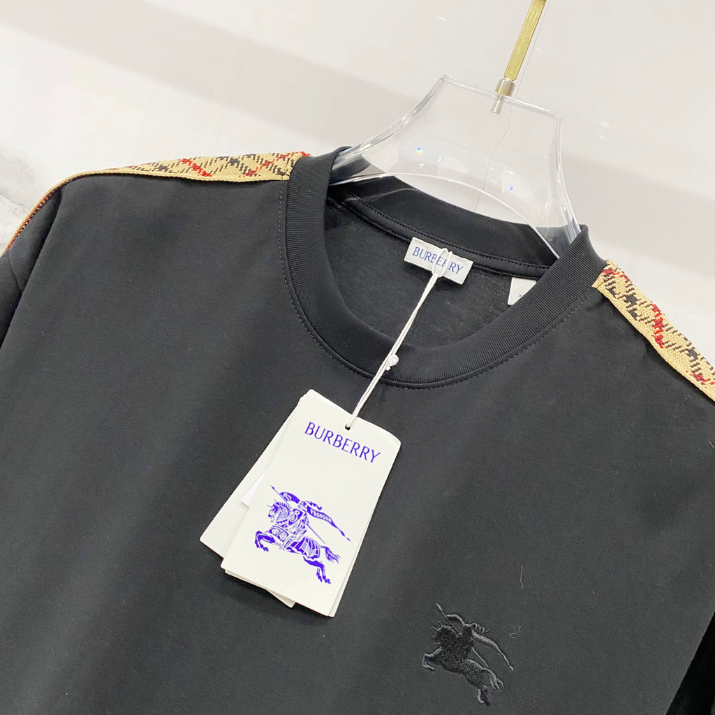 Black Burberry crew-neck T-shirt with multicolor trim on the shoulder, hangtag attached.