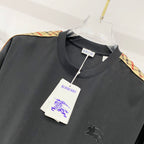 Black Burberry crew-neck T-shirt with multicolor trim on the shoulder, hangtag attached.
