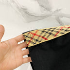 Black Burberry short-sleeve T-shirt sleeve close-up with multicolor trim band.