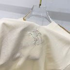 Cream T-shirt sleeve with raised horse logo embroidery