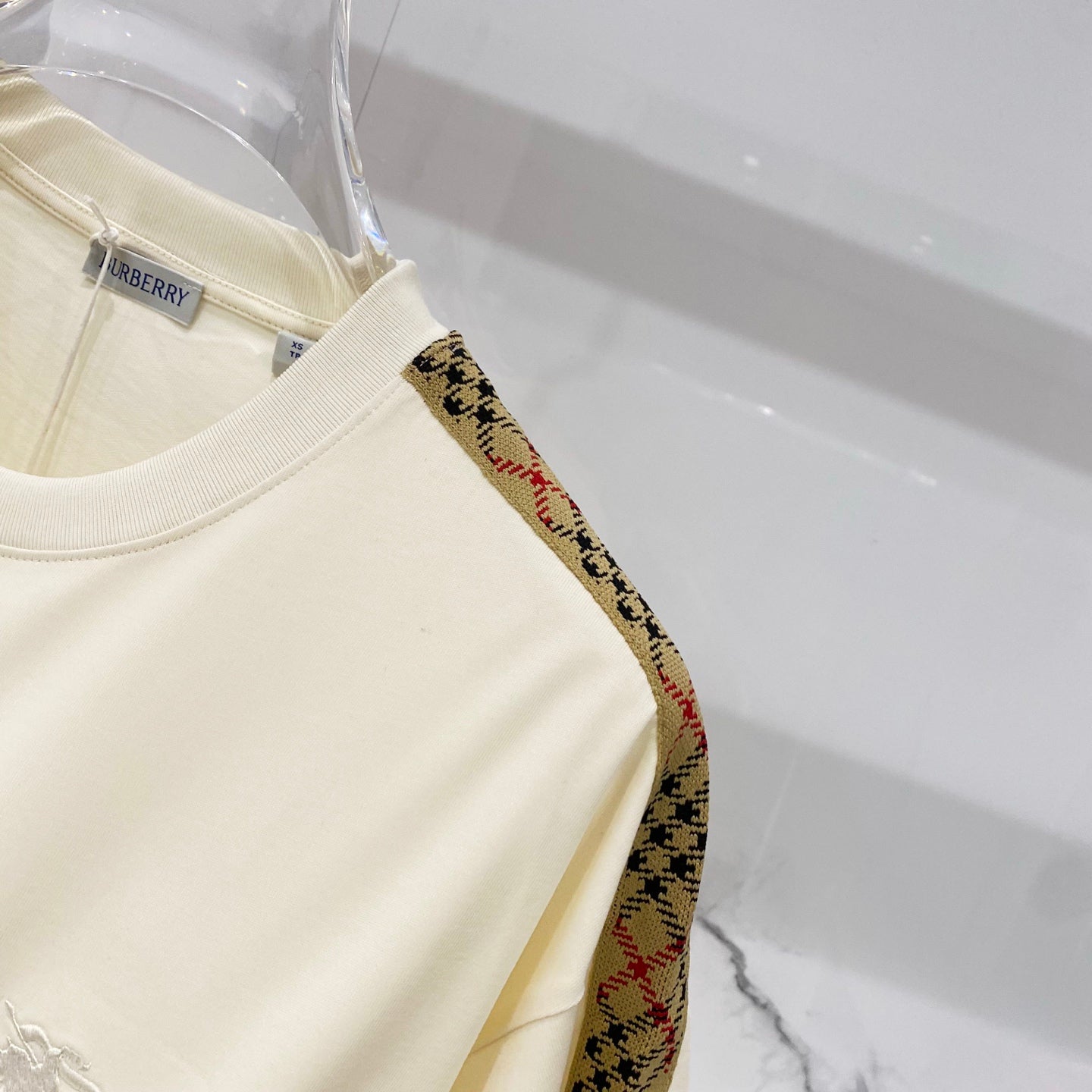 Cream T-shirt with multicolor patterned trim on shoulder seam