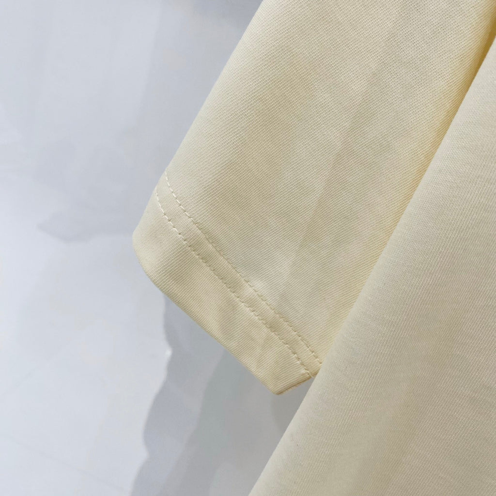 Cream T-shirt sleeve cuff with visible hem stitching