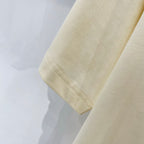 Cream T-shirt sleeve cuff with visible hem stitching