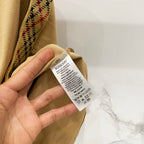 Mustard T-shirt inside neckline label close-up with Burberry tag and care info