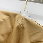 Mustard T-shirt fabric close-up with embroidered horse logo on the chest