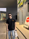 Black short-sleeve T-shirt with chest pocket and tan logo patch, front view