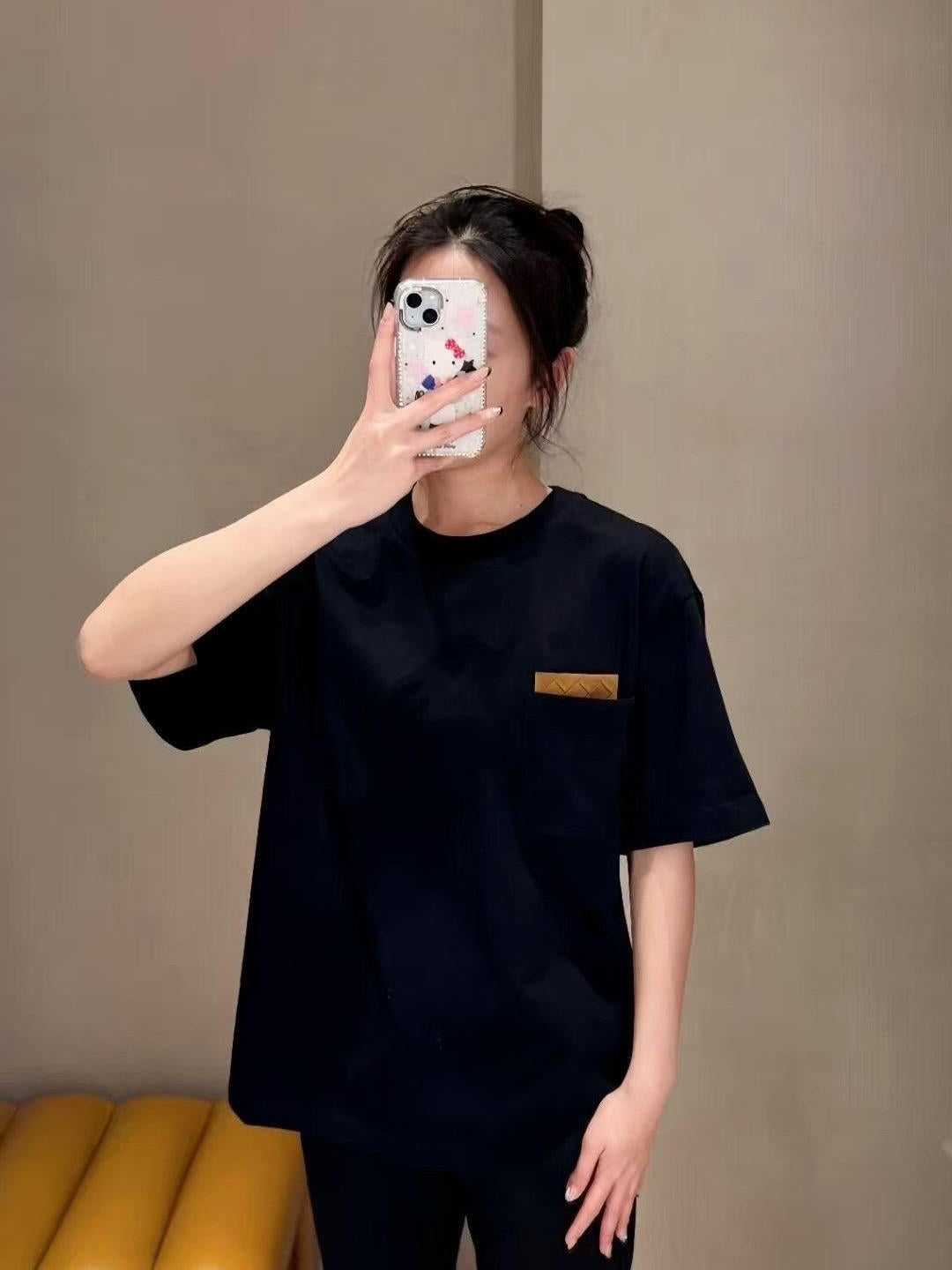 Dark short-sleeve top with chest pocket and small gold label