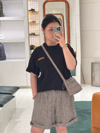 Dark short-sleeve top with chest pocket and checkered off-white shorts