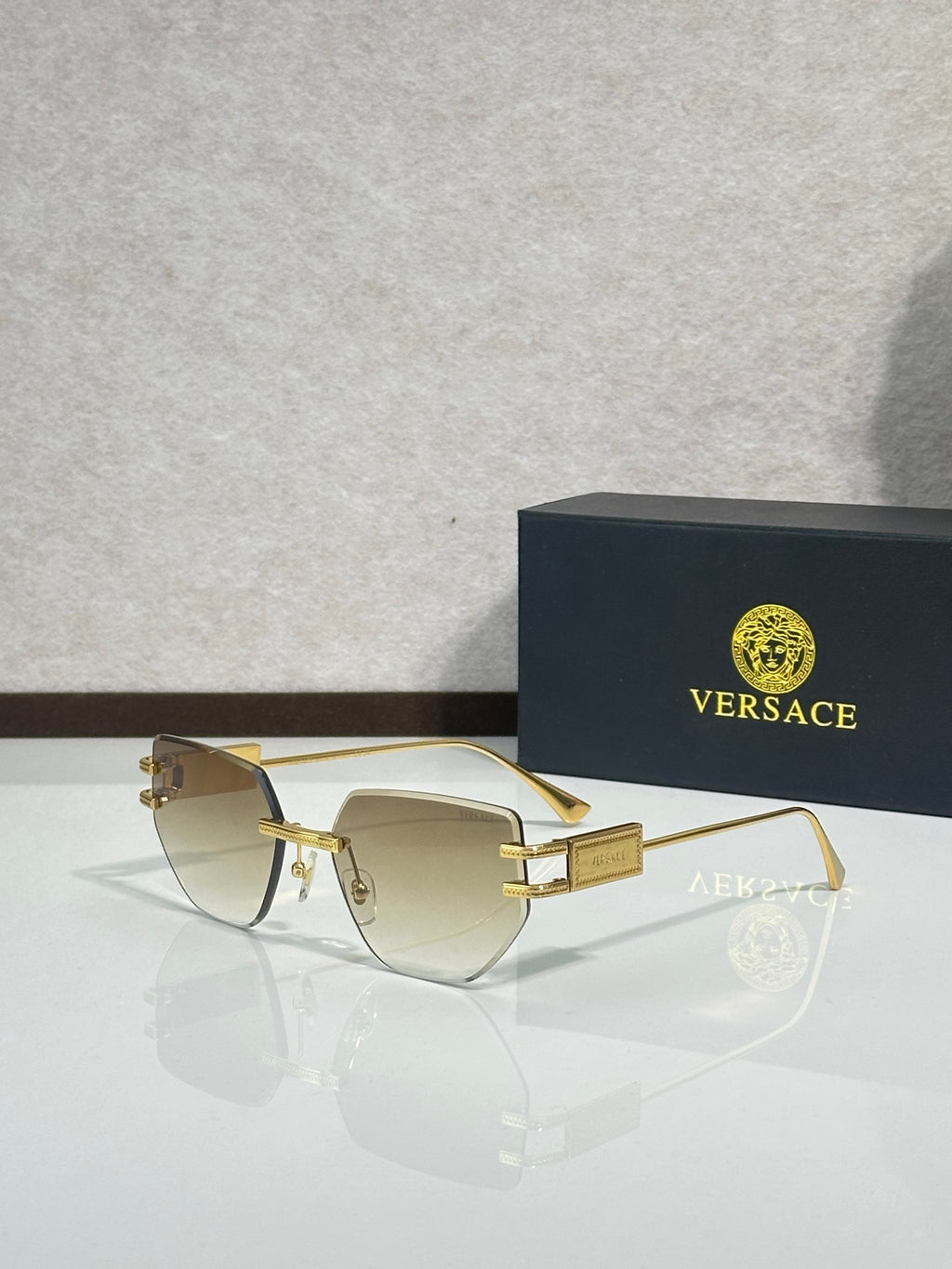 Versace eyeglasses with clear lenses and gold-tone metal frame, rectangular shape