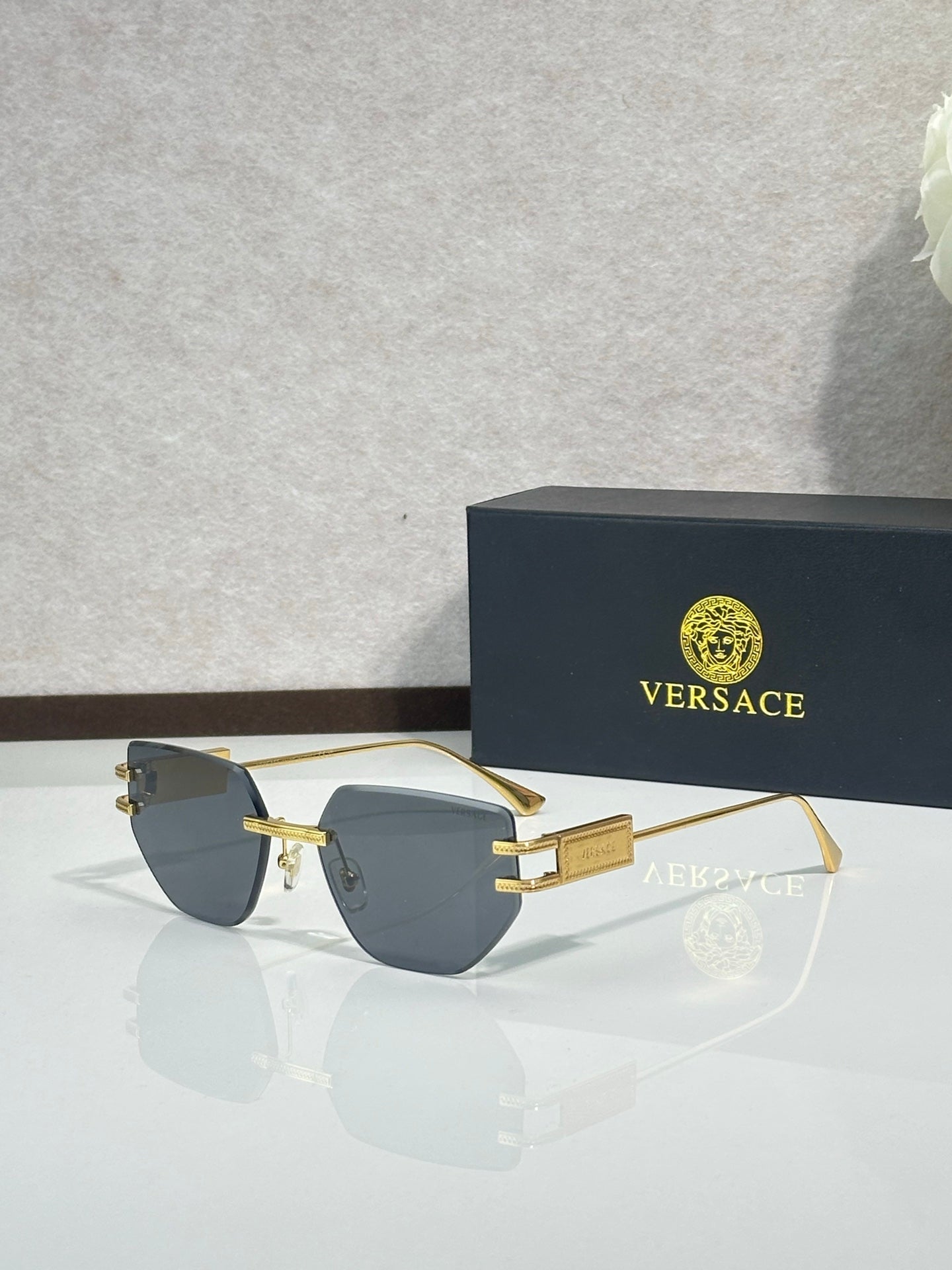 Versace eyeglasses with dark tinted lenses and gold-tone metal frame, rectangular shape