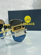 Versace sunglasses with dark blue lenses and gold-tone frame, logo detail on temple