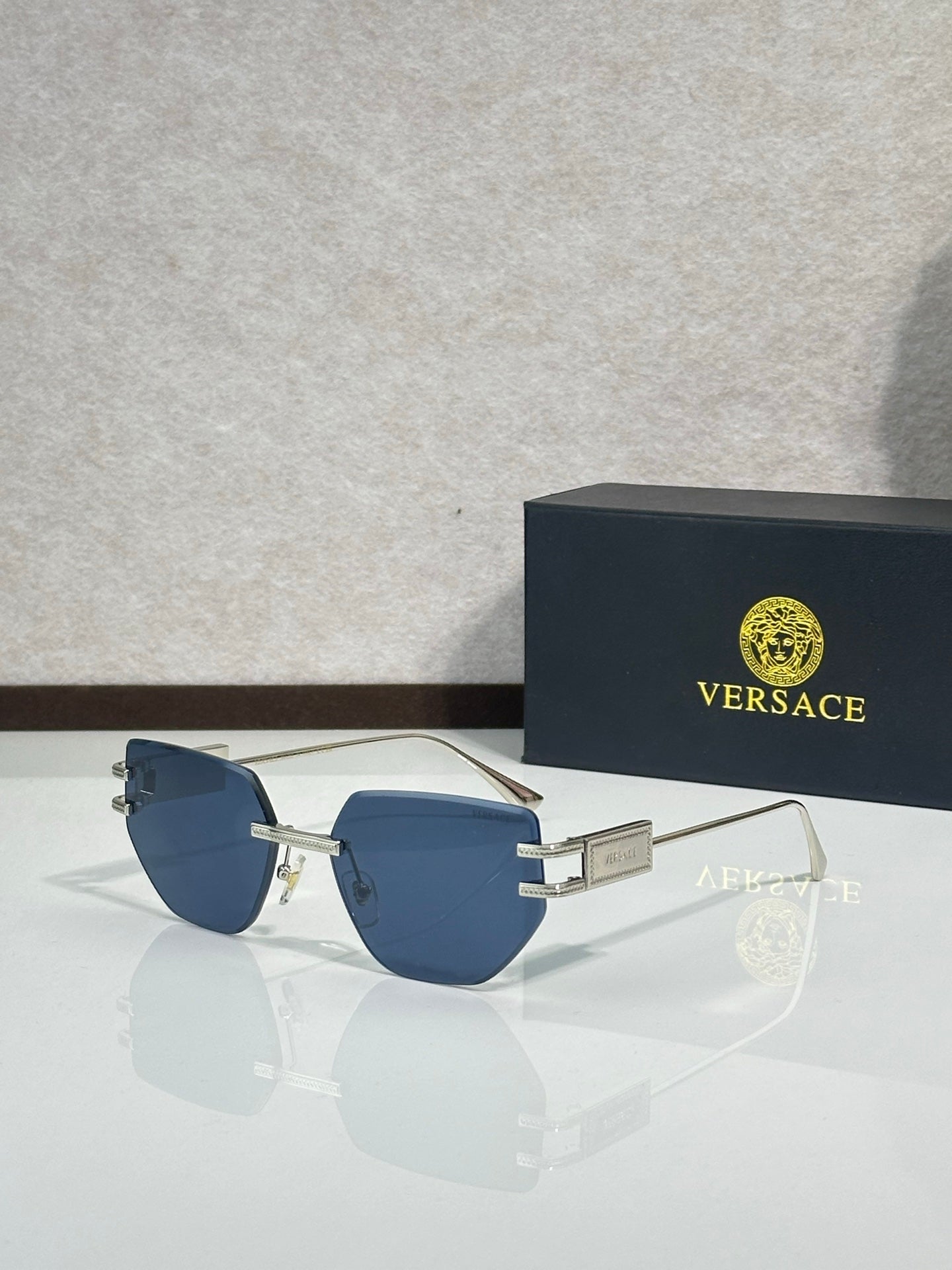 Versace eyeglasses with blue tinted lenses and gold-tone metal frame, rectangular shape