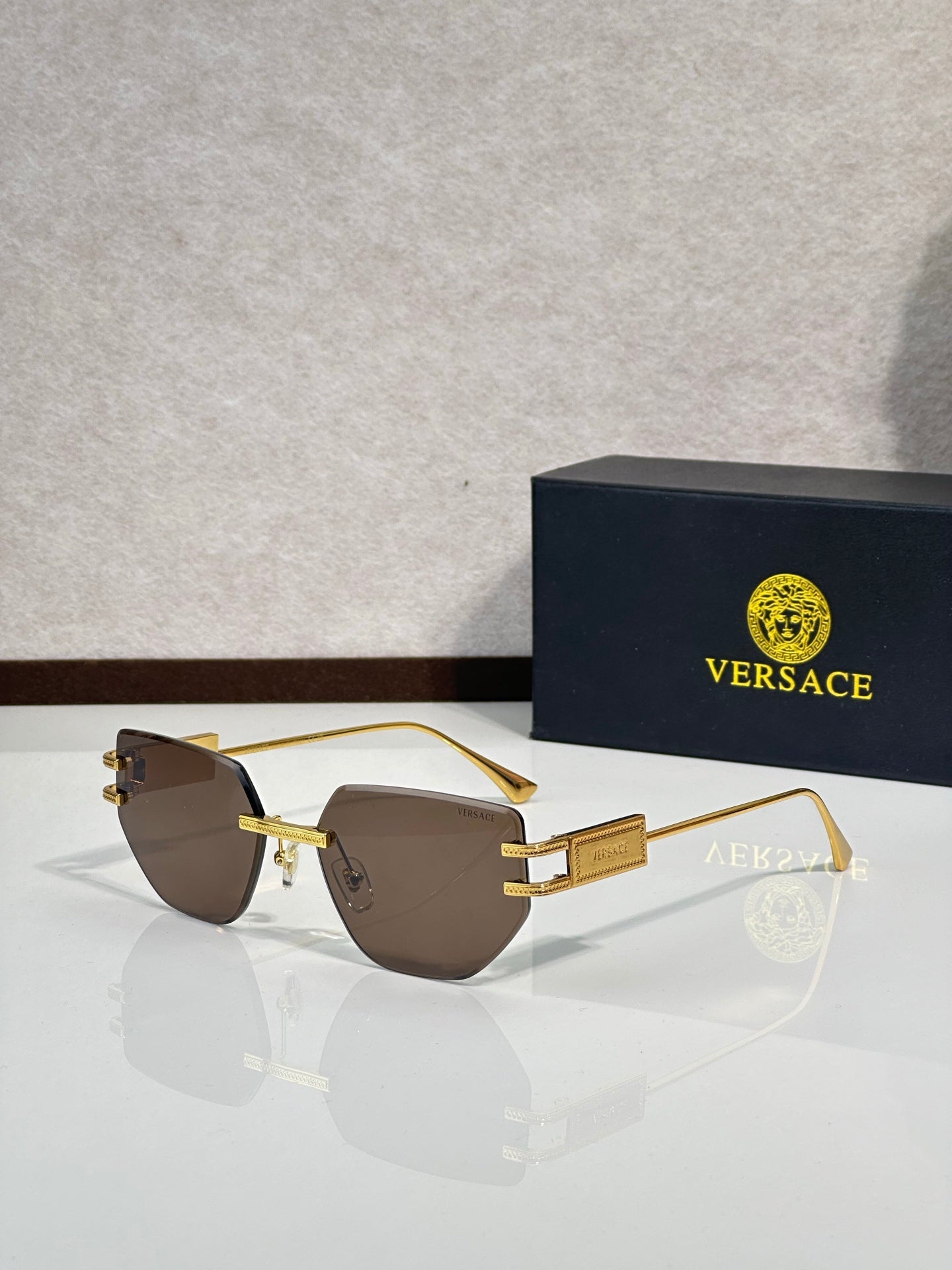 Versace eyeglasses with brown tinted lenses and gold-tone metal frame, rectangular shape