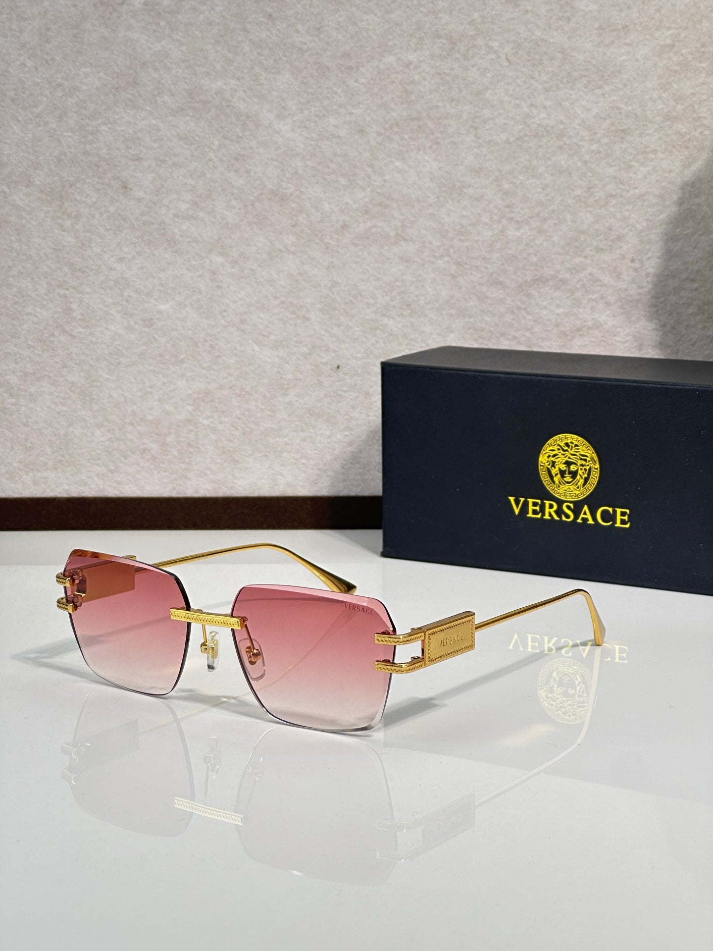 Versace sunglasses with gold metal frame and pink tinted lenses