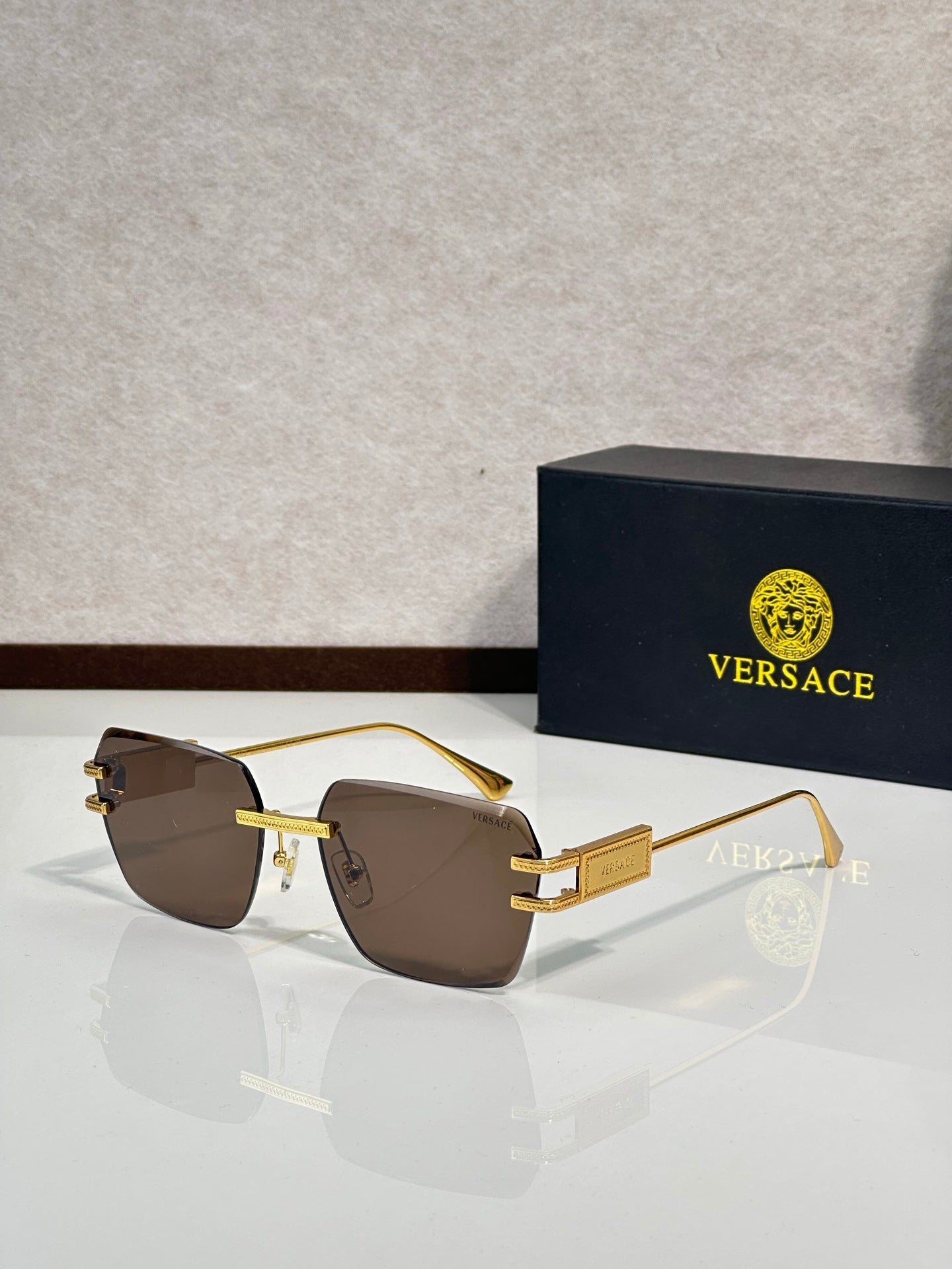 Versace sunglasses with gold metal frame and brown tinted lenses