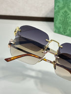 Overlapping gold-framed sunglasses with dark tinted lenses, side view