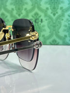 Gucci sunglasses close-up of dark lenses with gold-tone hinge and emblem detail