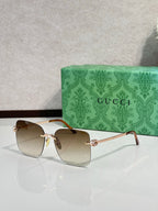 Gucci sunglasses with warm amber gradient lenses and gold-tone frame, front view