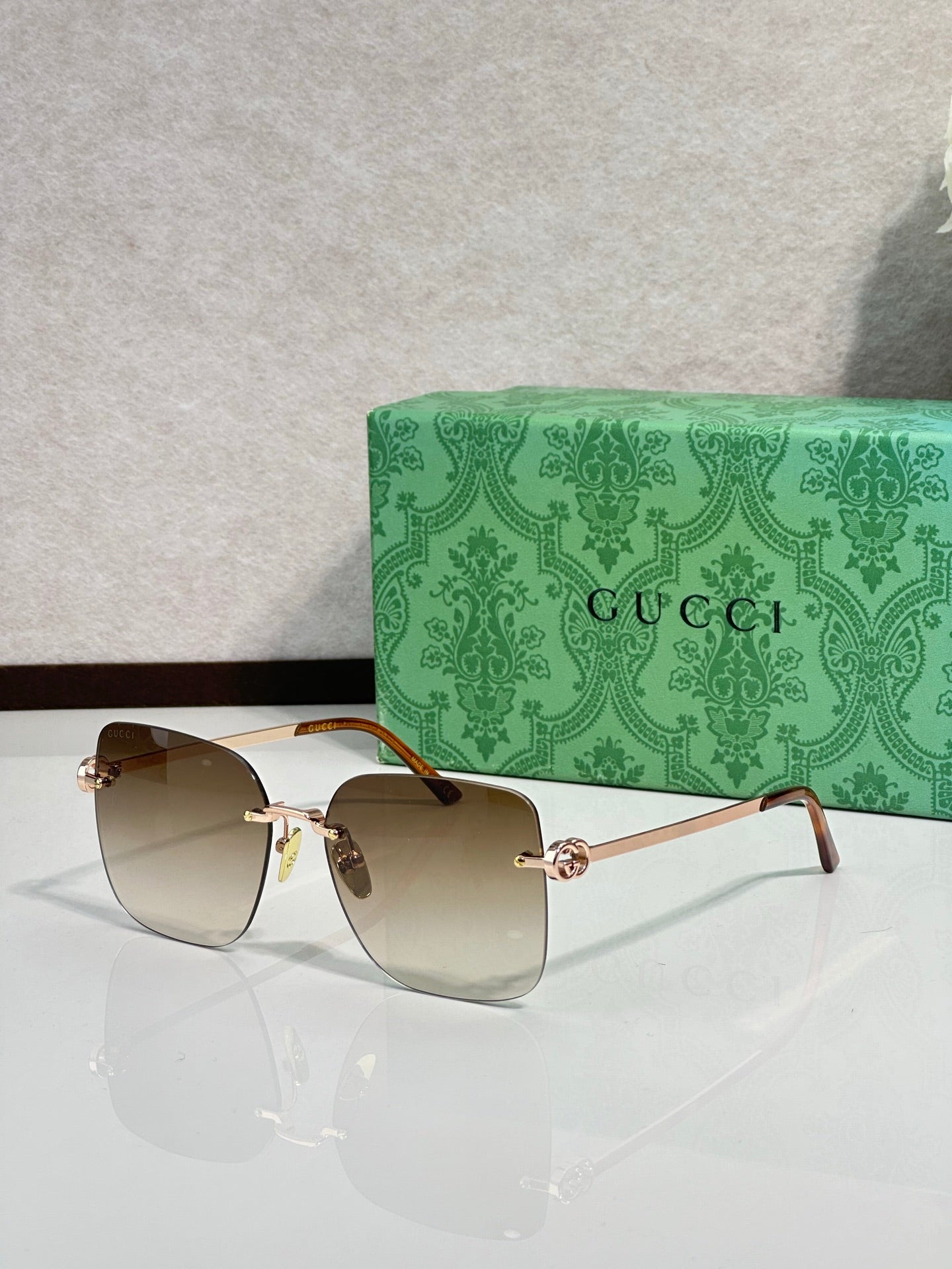 Gucci sunglasses with warm amber gradient lenses and gold-tone frame, front view