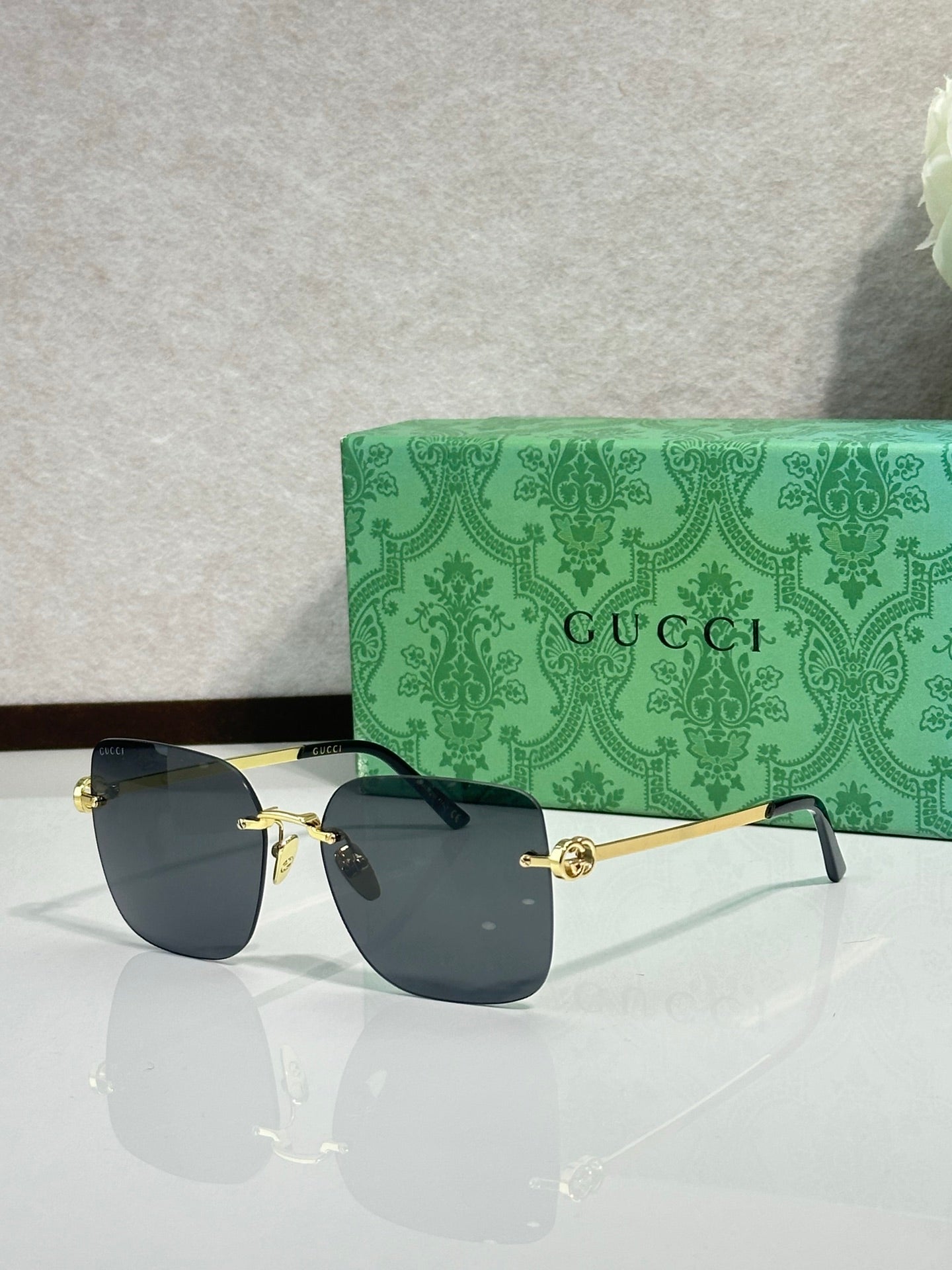 Gucci sunglasses with dark blue gradient lenses and gold-tone frame, side view