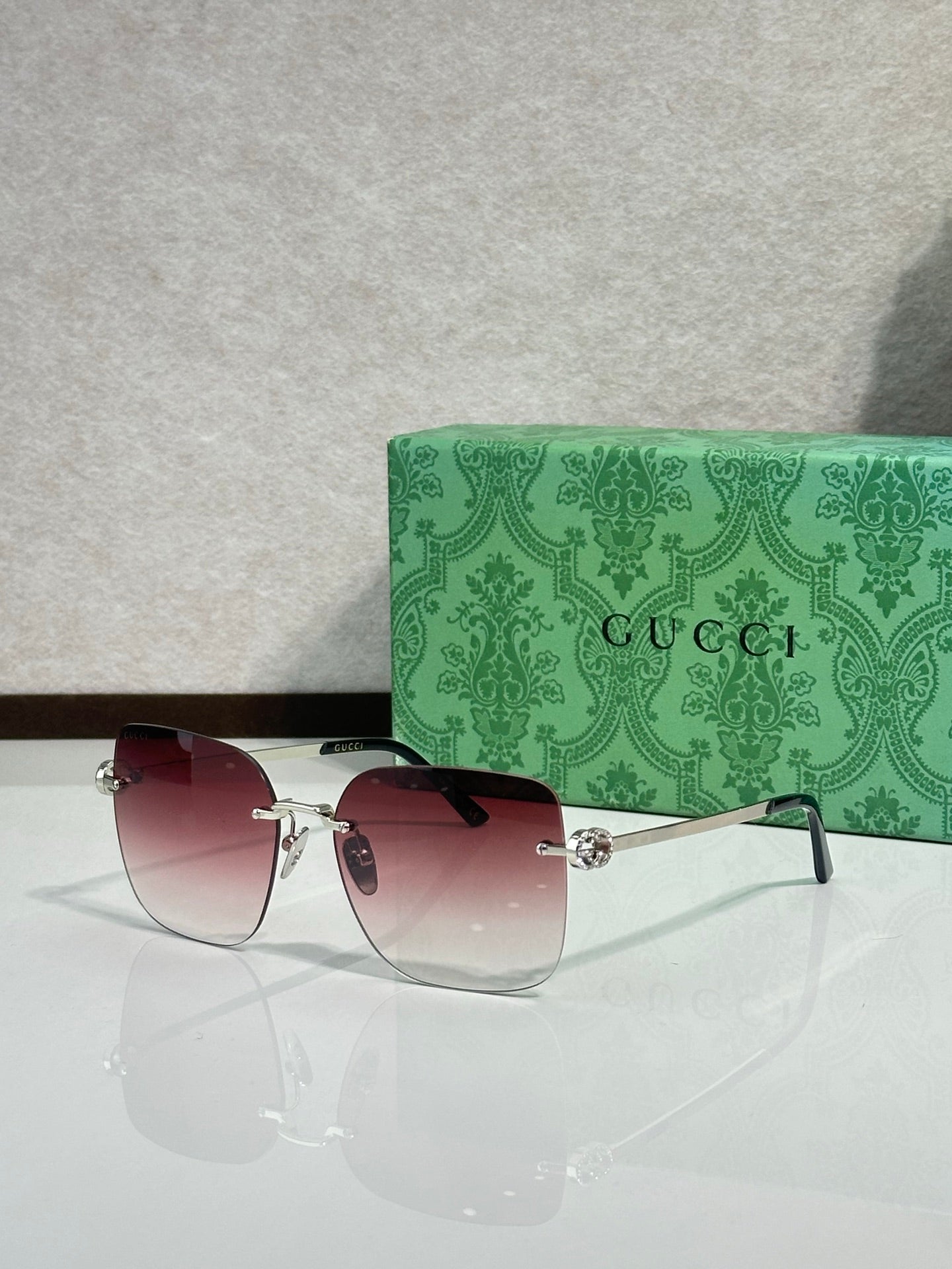 Gucci sunglasses with burgundy gradient lenses and gold-tone frame, front view