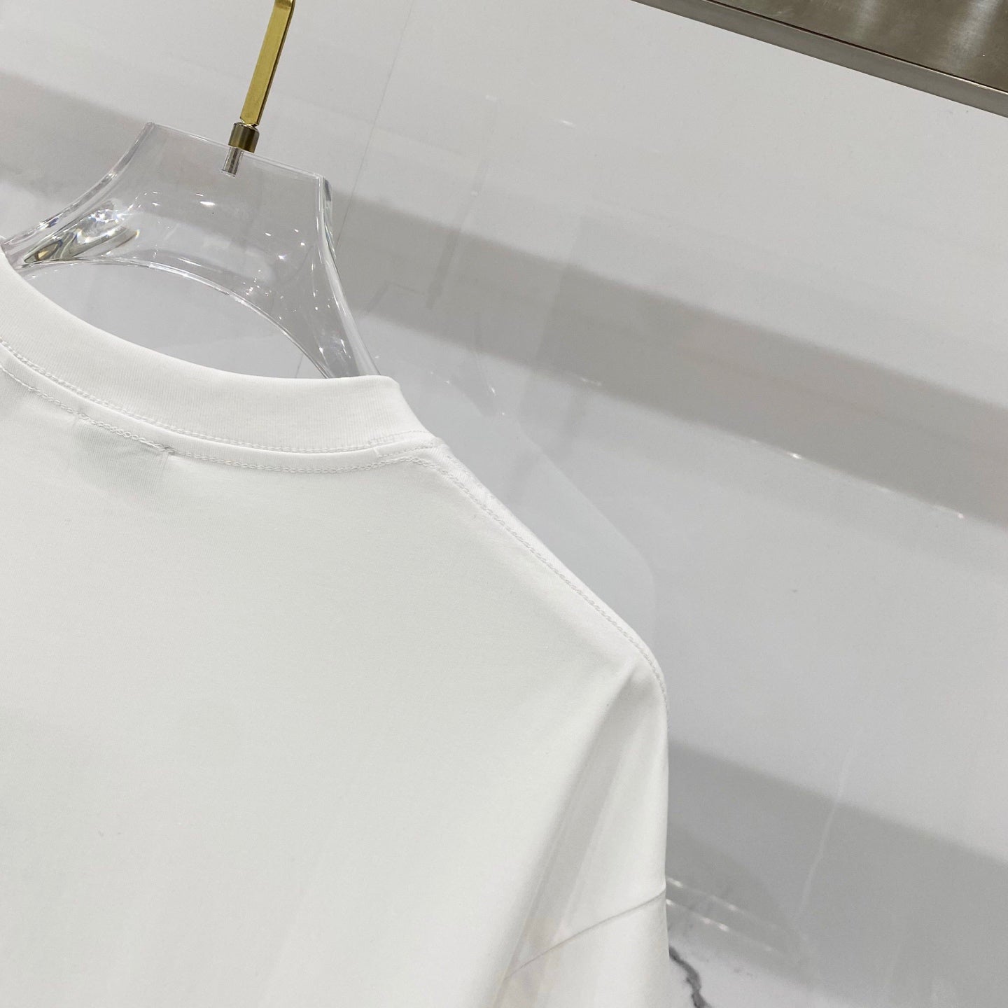White Burberry T-shirt shoulder seam and crew neckline close-up