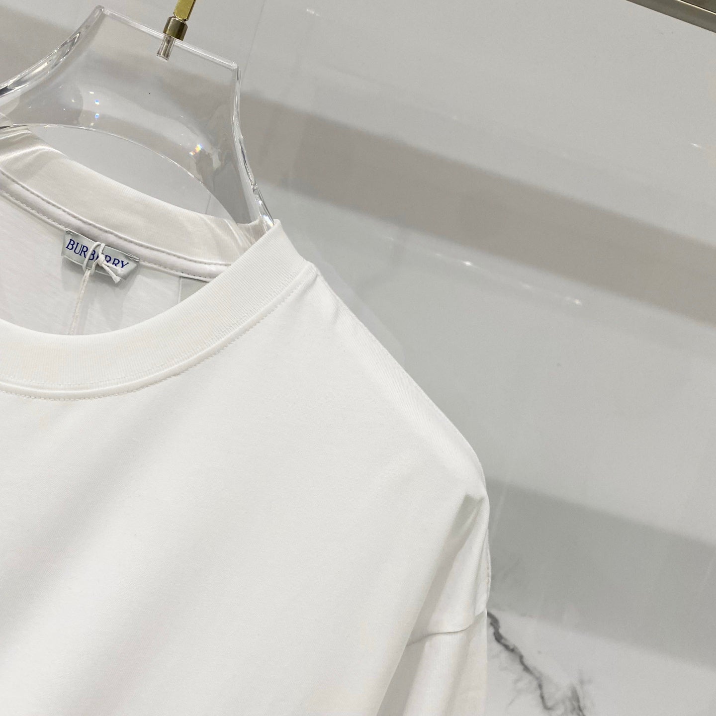 White Burberry T-shirt side view with clean sleeve and hem