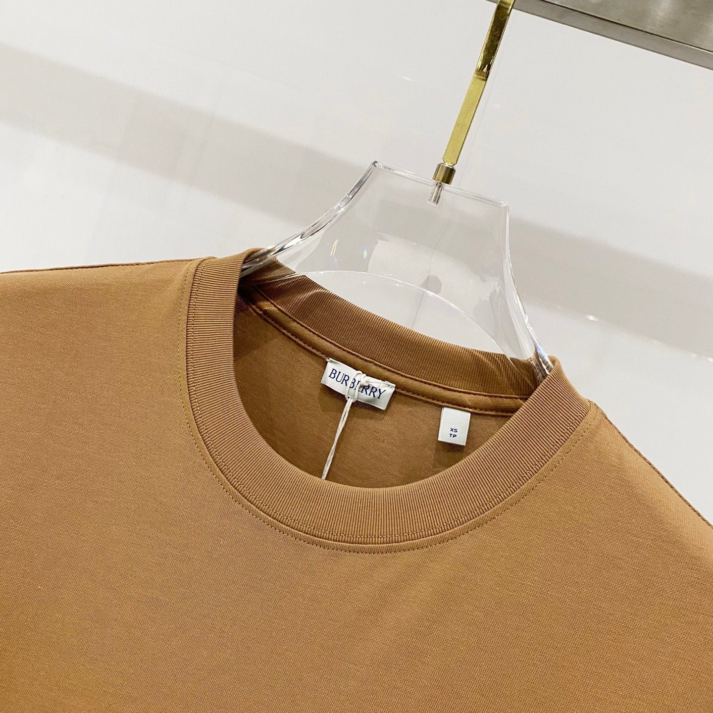 Tan Burberry crewneck T-shirt neckline with brand label inside collar