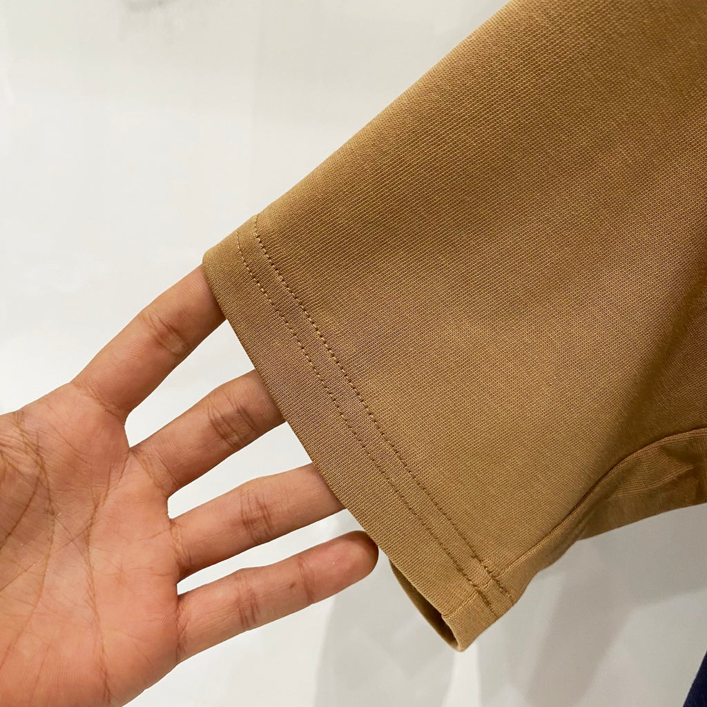 Tan short-sleeve T-shirt sleeve hem detail with stitched edge