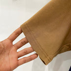 Tan short-sleeve T-shirt sleeve hem detail with stitched edge